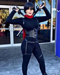 a woman dressed in black and red posing for the camera