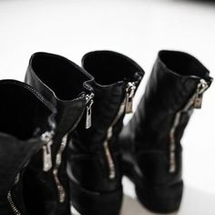 three pairs of black boots with zippers on them