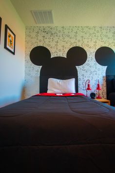 a bedroom with mickey mouse head on the wall