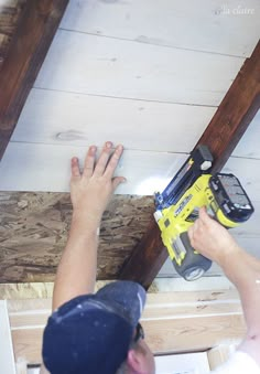 a man is using a drill to fix the wood on the ceiling in his house