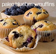 four blueberry muffins sitting on top of a cutting board