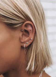 a close up of a person with ear piercings on their ears and behind the ear