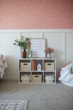 there is a shelf with baskets and books on it