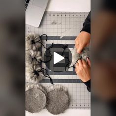 a person is cutting fur with scissors on a table next to a laptop and other items