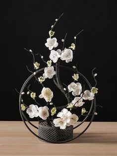 an arrangement of white flowers in a black vase