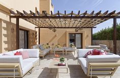 an outdoor living area with couches and tables