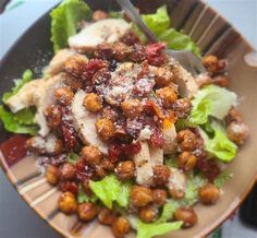 a salad with meat, lettuce and cranberries in it on a plate