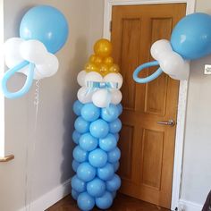 blue and white balloons are on the floor next to a door