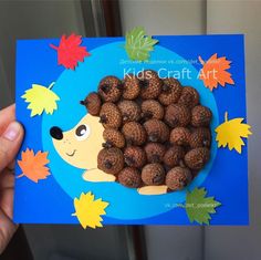 a person holding up a card with some pine cones in the shape of a hedge