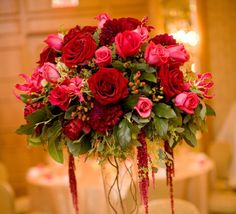 a vase filled with red roses on top of a table