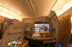 the inside of an airplane with several tables and televisions on each plane's sides