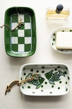 green and white trays with fish on them next to soap bars, toothbrushes and other items