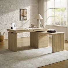 an office desk in front of a window with a lamp on the side and a rug underneath it