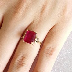 Gold and simulated red Ruby ring.   Ring is made with 9 carat yellow gold.  Simulated red Ruby is Emerald cut and measures 10mmsx8mms. Ring size is L (Australian size) or 5 1/2 (US size). Ring is ready to ship in 1-2 working days.  We resize free of charge.  Please allow a couple of additional days for resizing. This ring can be custom made to your specification.  Contact us with your queries. All my rings come in a velvet ring box. Classic Lab-created Ruby Rings For Promise, Yellow Gold Ruby Ring With Accent Stones For Promise, Gold Rings With Ruby Center Stone, Classic Red Ruby Ring In 14k Gold, Gold Ruby Ring With Emerald Cut And Accent Stones, Gold Ruby Crystal Ring With Prong Setting, Classic Promise Ring With Lab-created Ruby, Gold Ruby Ring With Accent Stones For Promise, Emerald Cut 14k Gold Ruby Promise Ring