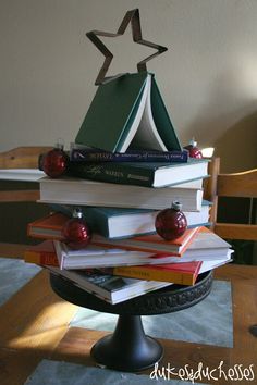 a stack of books sitting on top of a table next to a christmas ornament