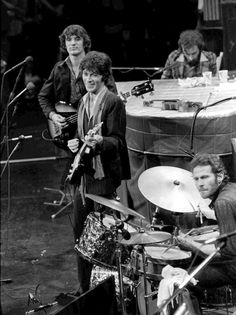 the rolling stones playing drums in front of microphones