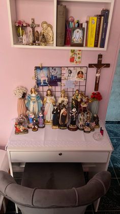 a white desk topped with lots of figurines on top of it next to a shelf