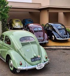 three different colored cars parked in front of a building