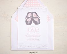 a pair of baby shoes on top of a card