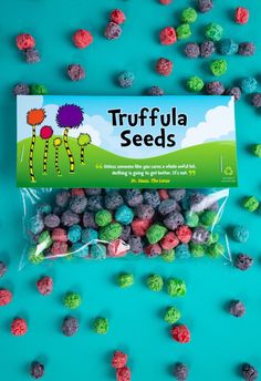 a bag of truffula seeds sitting on top of a blue surface next to green and red candies