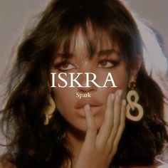 a woman holding her hand to her face with the words iskra in front of her