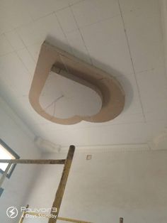 an unfinished ceiling with a hole in the middle and a ladder up to it's right