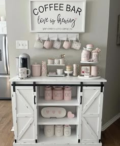 a coffee bar is decorated with pink and white decor