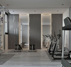 there are many treadmills in the room with mirrors on the wall and other exercise equipment