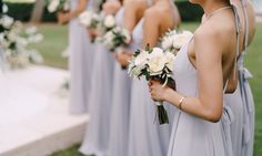 a group of women standing next to each other holding bouquets