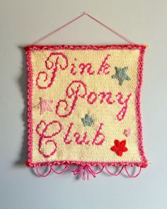 pink pony club sign hanging on the wall