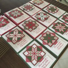 several quilted snowflakes are arranged on a table with red and green accents