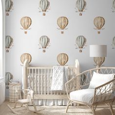 a baby's room with hot air balloons on the wall