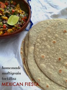 three tortillas sitting on top of a white table cloth next to a bowl of salsa