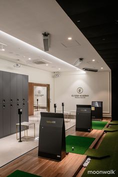 a room filled with lots of lockers and green carpeted flooring in front of white walls