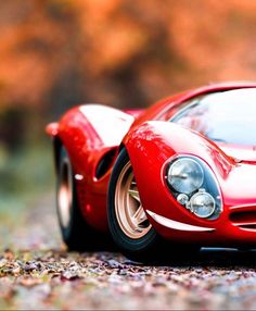 a red sports car is parked on the ground