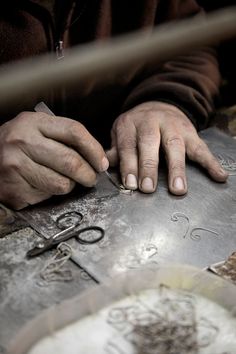 a person with their hands on a metal object