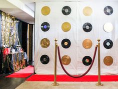 there are many records on the wall with red carpet and gold poles in front of them