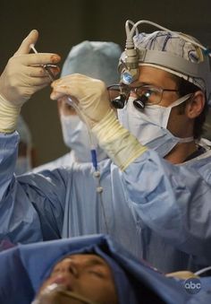 two doctors are performing surgery on a patient