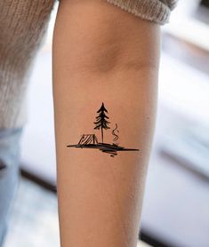 a woman's arm with a small pine tree tattoo on the left side of her leg