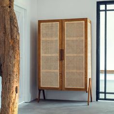 a tall wooden cabinet sitting next to a window