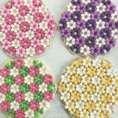 four crocheted coasters with different colors and designs on the top one is pink, green, yellow, purple, and white