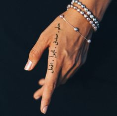 a woman's hand with writing on it and two bracelets around her wrist