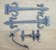 an assortment of old metal hardware on a wooden floor with nails and wrenches attached to it