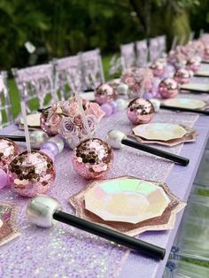 the table is set with pink and purple decorations