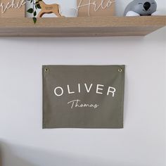 there is a sign on the wall that says, oliver thannes and an elephant figurine next to it