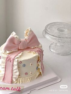 a white cake with pink bows on top