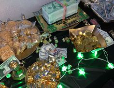 a table topped with lots of money and gold coins next to stacks of cash on top of each other