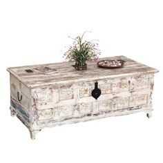 an old chest with flowers on it and a plate sitting on the top that has a flower pot in it