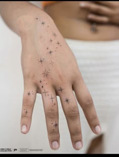 a woman's hand with stars tattooed on it