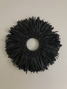 a circular black object on a white wall